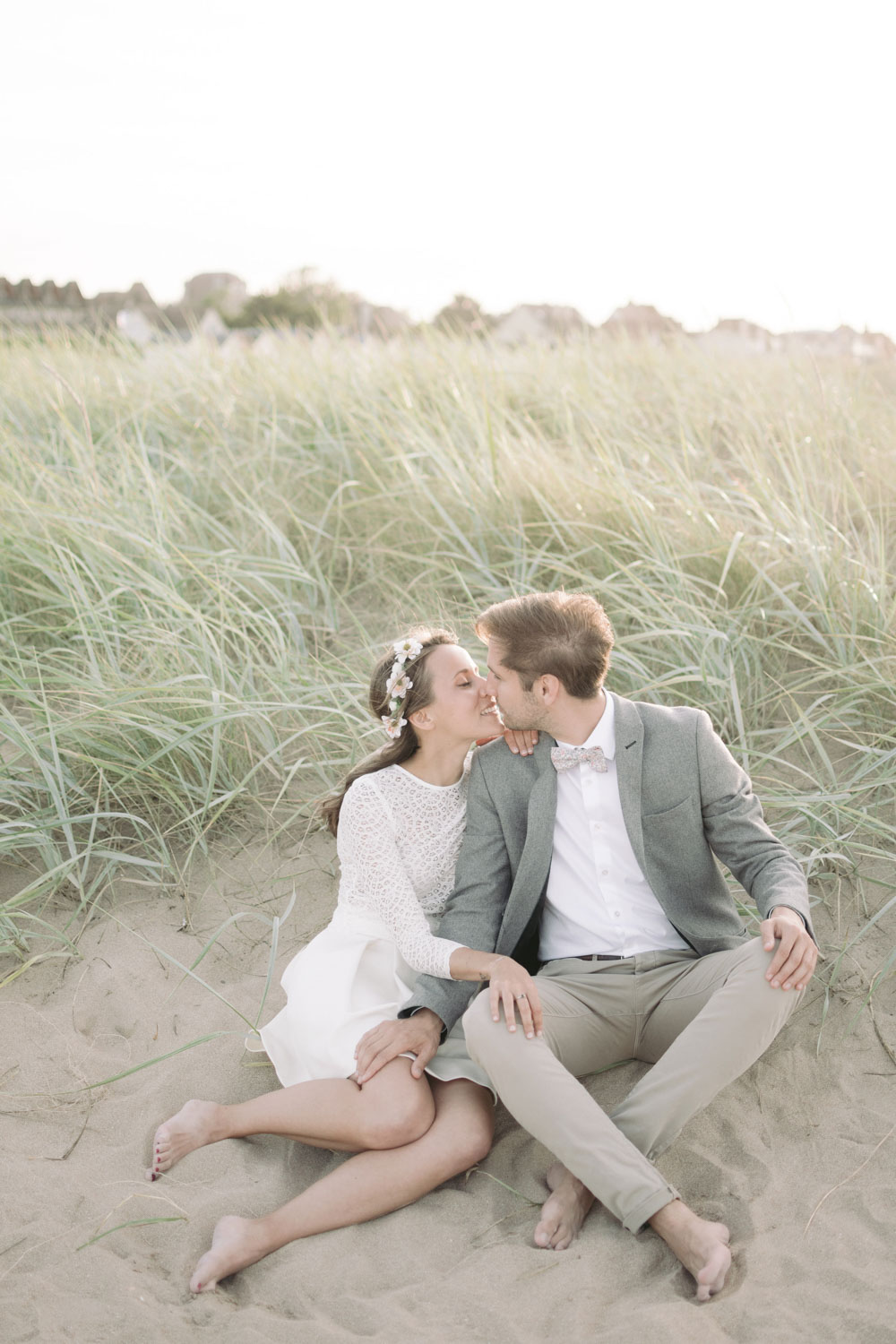 Assis dans le sable ils s'embrassent